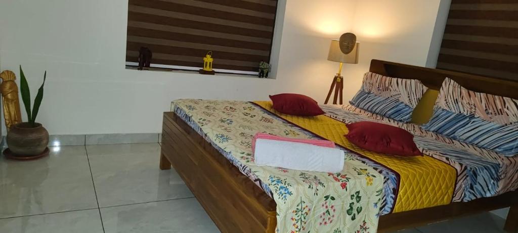 a bedroom with a bed with red pillows at The Mystery palace in Varkala