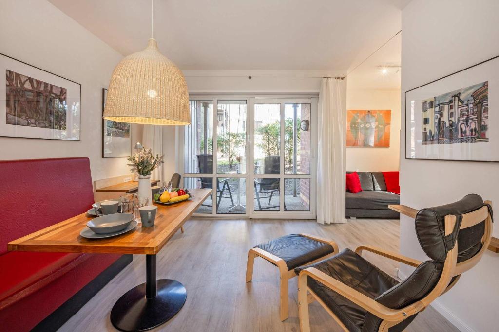 a living room with a wooden table and chairs at Ferienanlage Seeblick Kunstquartier in Koserow