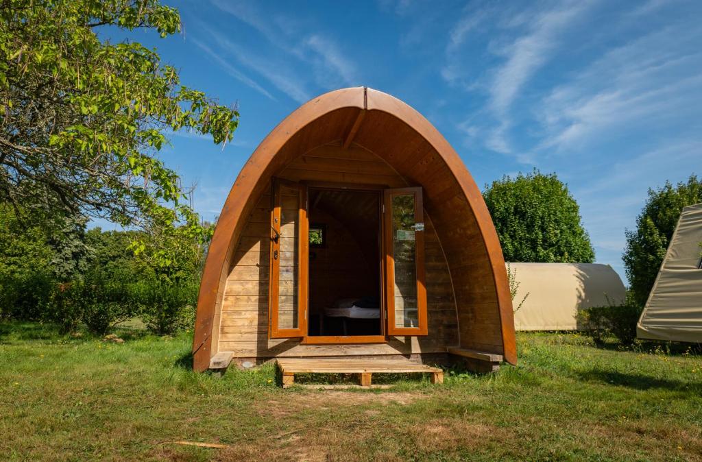 a small wooden hobbit house in a field at Camping Onlycamp le Clos Imbert in Thouars