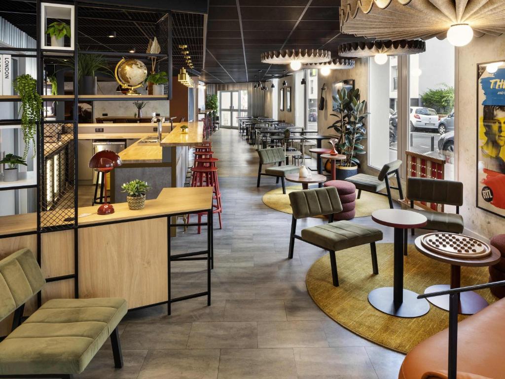 a restaurant with tables and chairs and a bar at ibis Paris Nation Davout in Paris