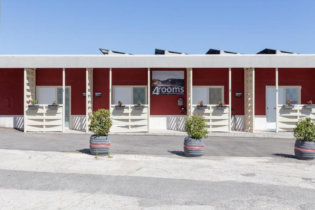 a red building with three potted plants in front of it at Vulcanica By Dimorra in Pozzuoli