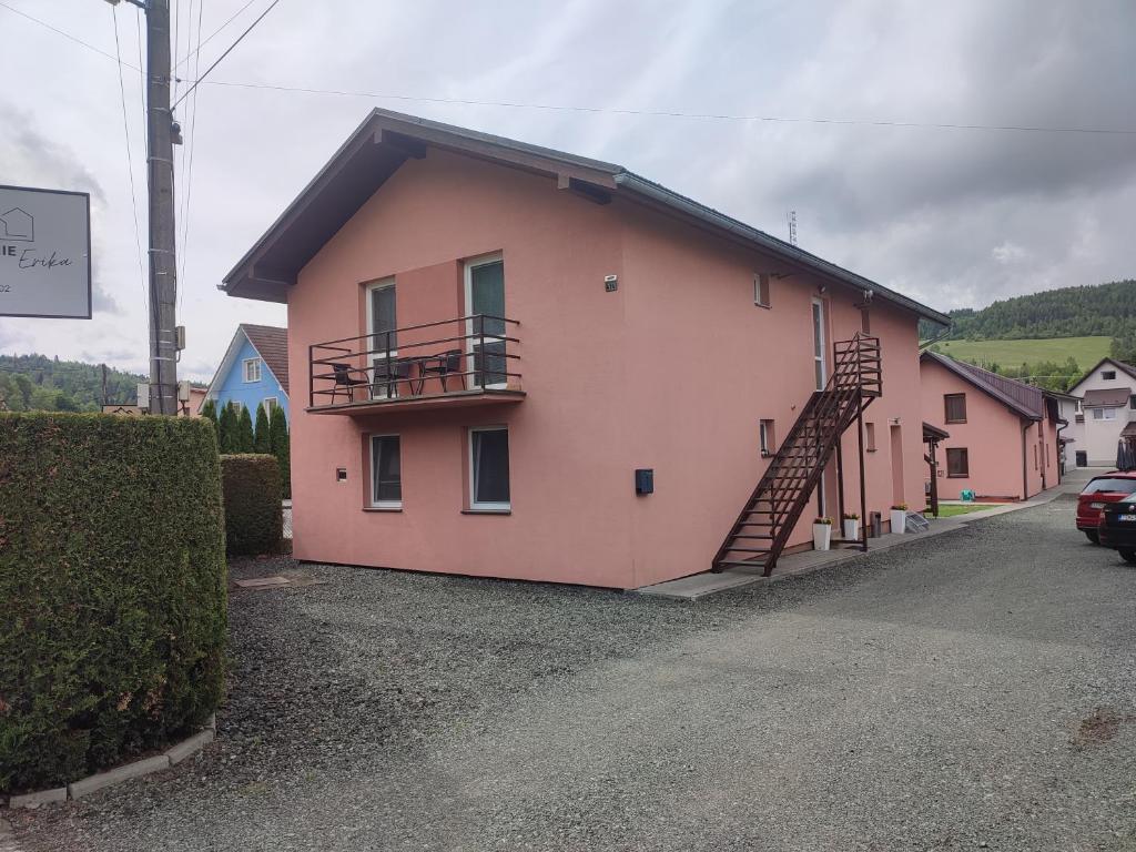 a pink house with a staircase on the side of it at Ubytovanie Erika in Vitanová