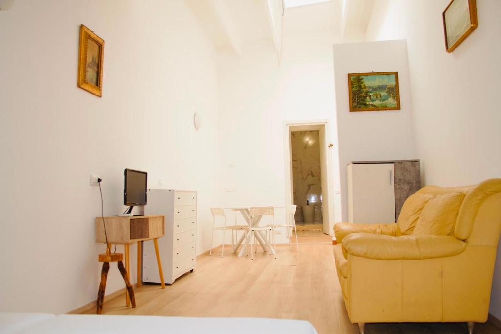 a living room with a yellow couch and a television at CR BnB Rozzano 2 in Rozzano