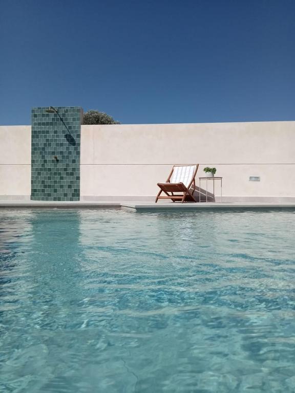 a chair sitting on the side of a swimming pool at La Pionera in Mejorada