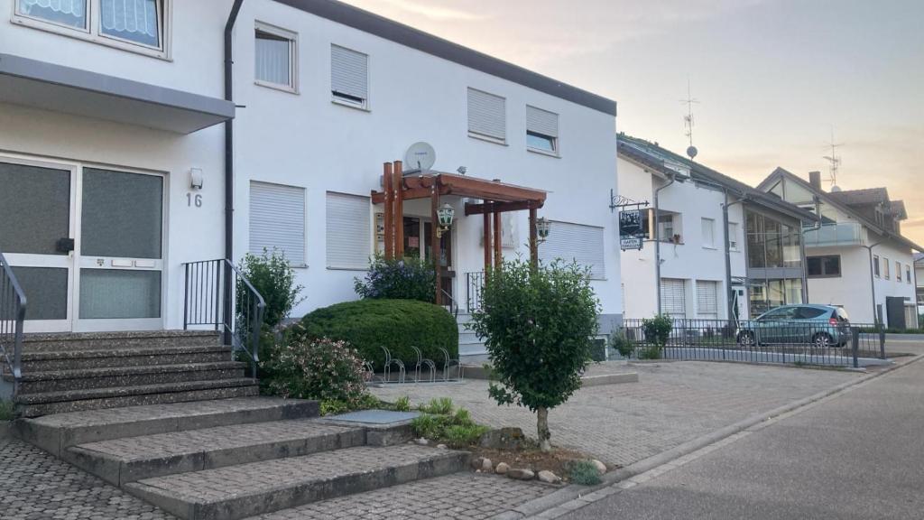 a white house with a staircase in front of it at Gasthaus Mösle in Oberreute