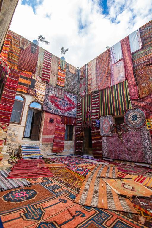 a pile of colorful carpets on the side of a building at Rocinante House in Mardin