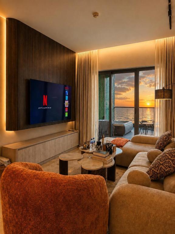 a living room with couches and a flat screen tv at برج داماك الجوهرة جدة - Damac Al Jawharah Tower in Jeddah