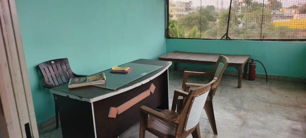 a room with two chairs and a desk and a table at Sri lucky grand lodge and function hall in Raigīr