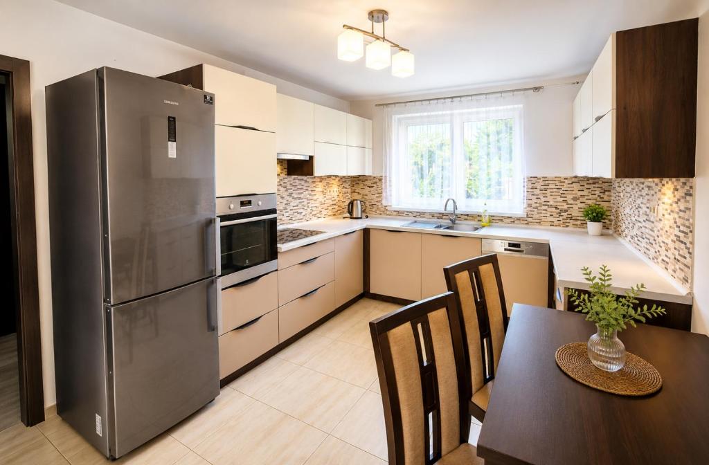 a kitchen with a stainless steel refrigerator and a table at Apartmán Hollého in Žilina