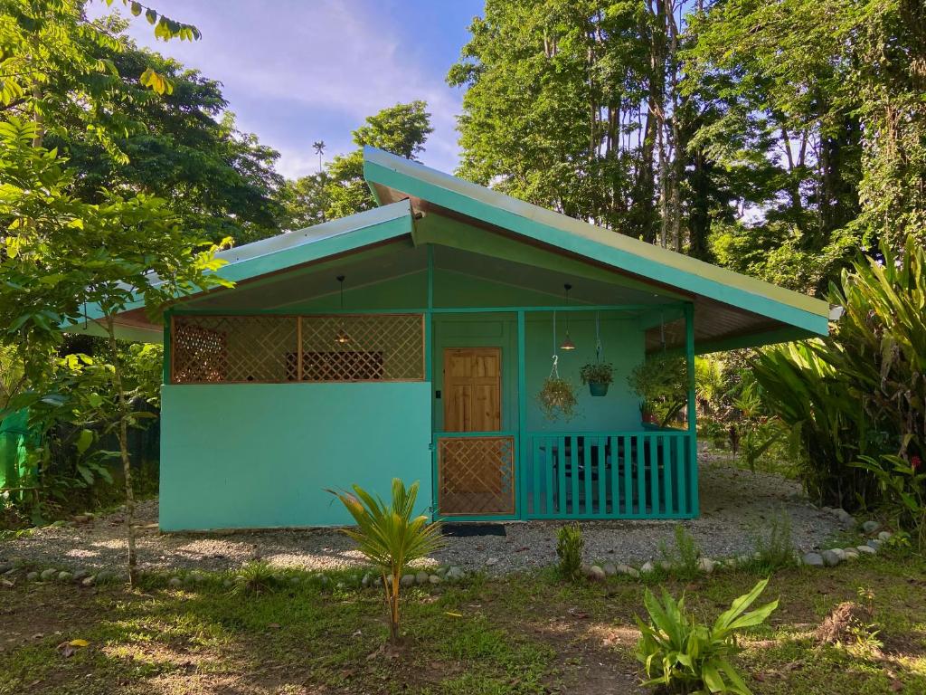 a blue building with a door in a yard at Lugar Mágico in Puerto Viejo