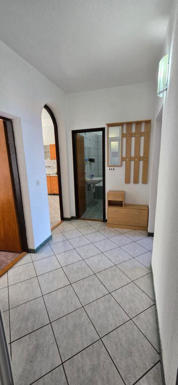 an empty room with a tile floor and a bathroom at Karmen 2 in Sveti Juraj