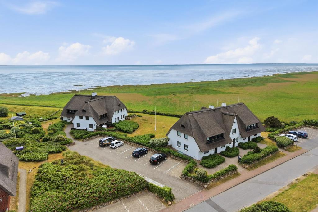 an overhead view of two white houses and the ocean at Wattkieker-Stedum in Rantum