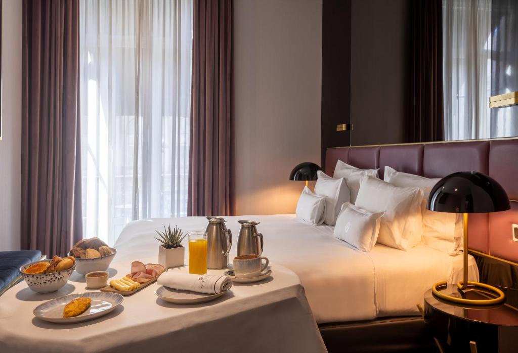 A double room photographed with a breakfast tray arranged across the bed.