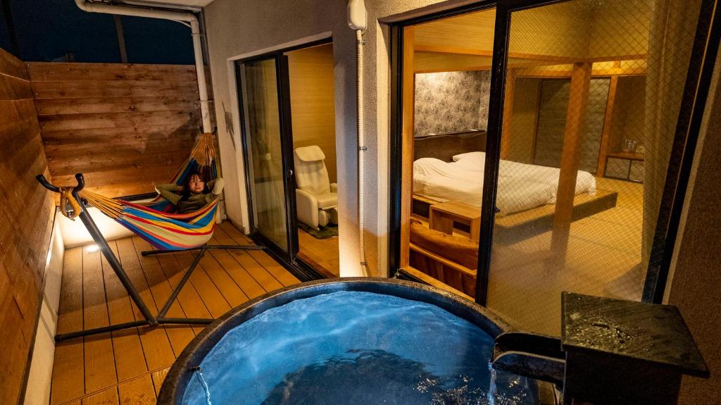 a jacuzzi tub in a room with a bedroom at Hanasuishou in Fuefuki