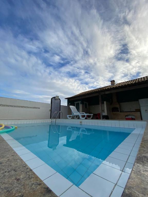 a swimming pool in a yard with a house at Casa c ar cond, wifi, a 5 min Orla da Lagoa Para Famílias in Araruama
