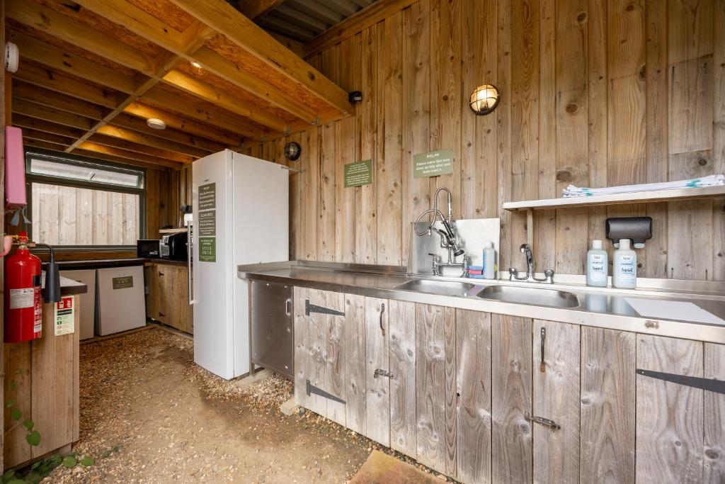 a kitchen with a sink in a wooden cabin at Container 2, Camp Tapnell in Yarmouth