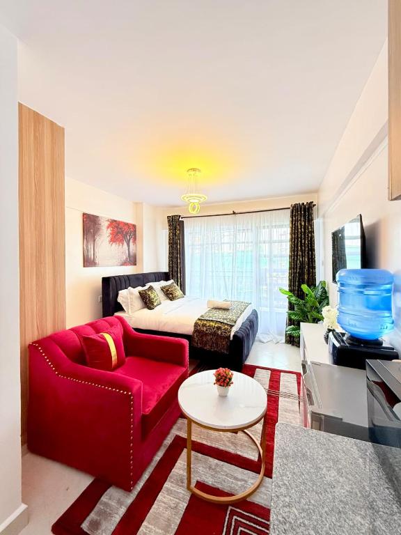 a living room with a red couch and a bed at Ethanira Homes Ngara in Nairobi