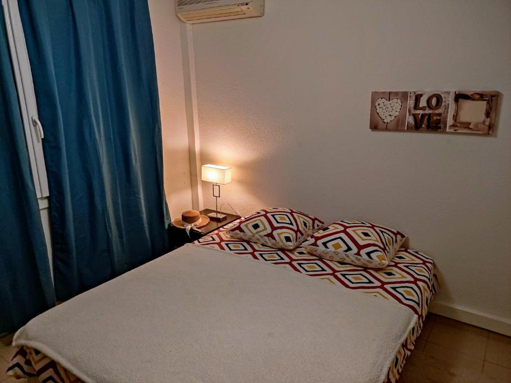 a small bedroom with a bed with a blue curtain at Villa au Cœur du Centre - Jardin & Terrasse, Parking Gratuit in Aix-en-Provence