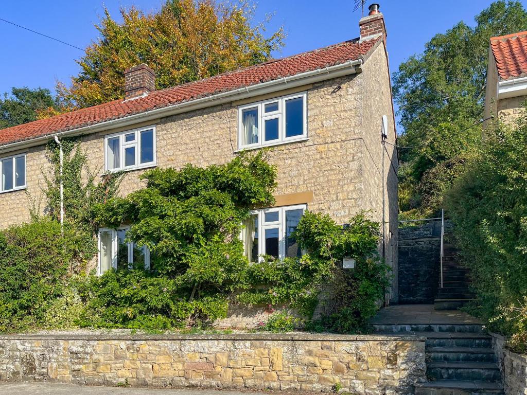an old brick house with stairs in front of it at St Anthonys in Ampleforth