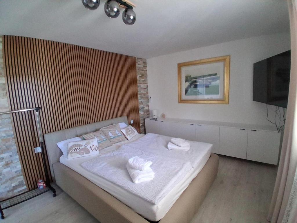 a bedroom with a bed with white sheets and towels at Apartment Matija in Stara Novalja