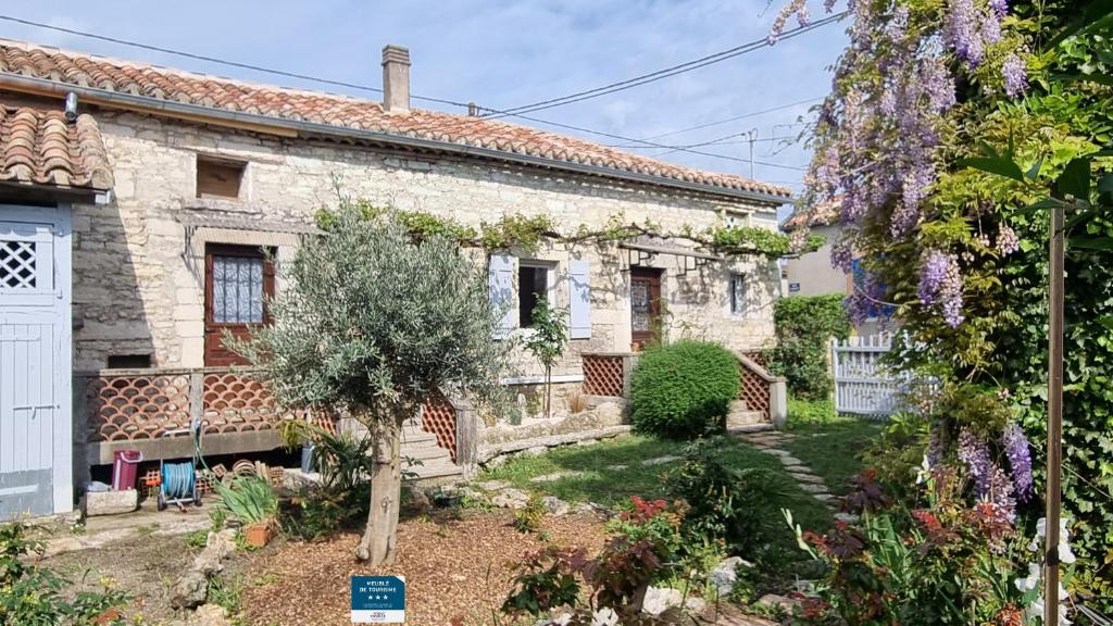 a stone house with a garden in front of it at Maison de Pierre in Septfonds