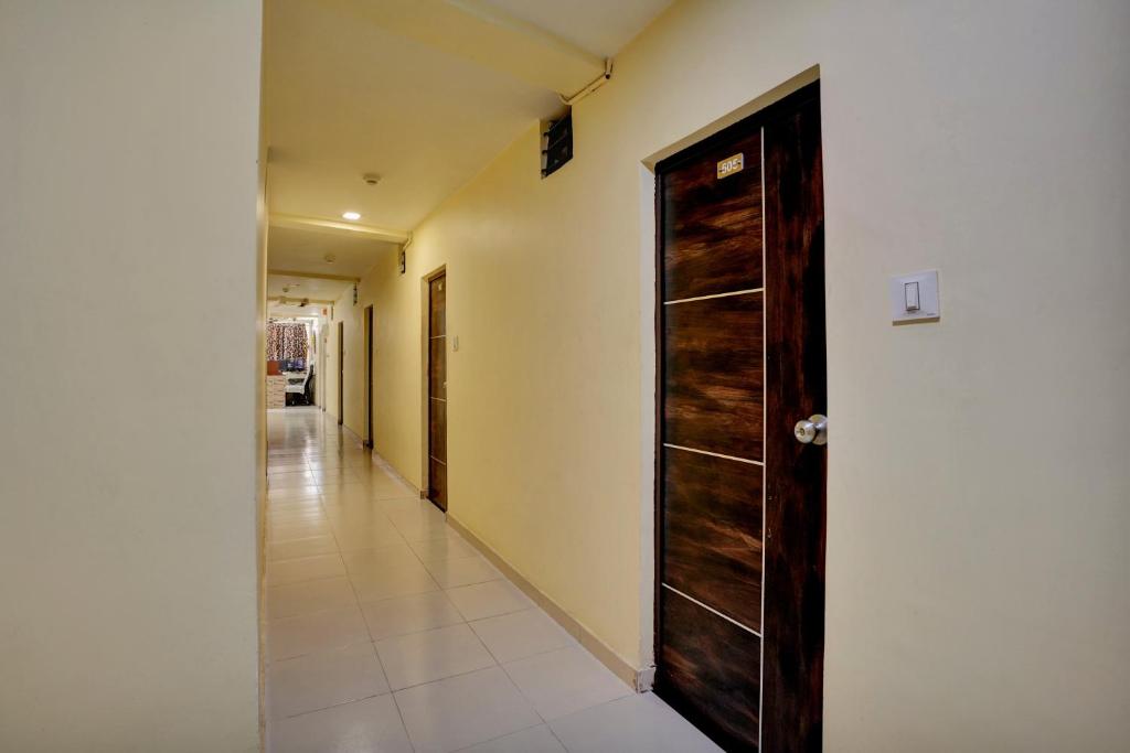 a hallway with a wooden door in a room at Hotel O Konark Inn in Naroda