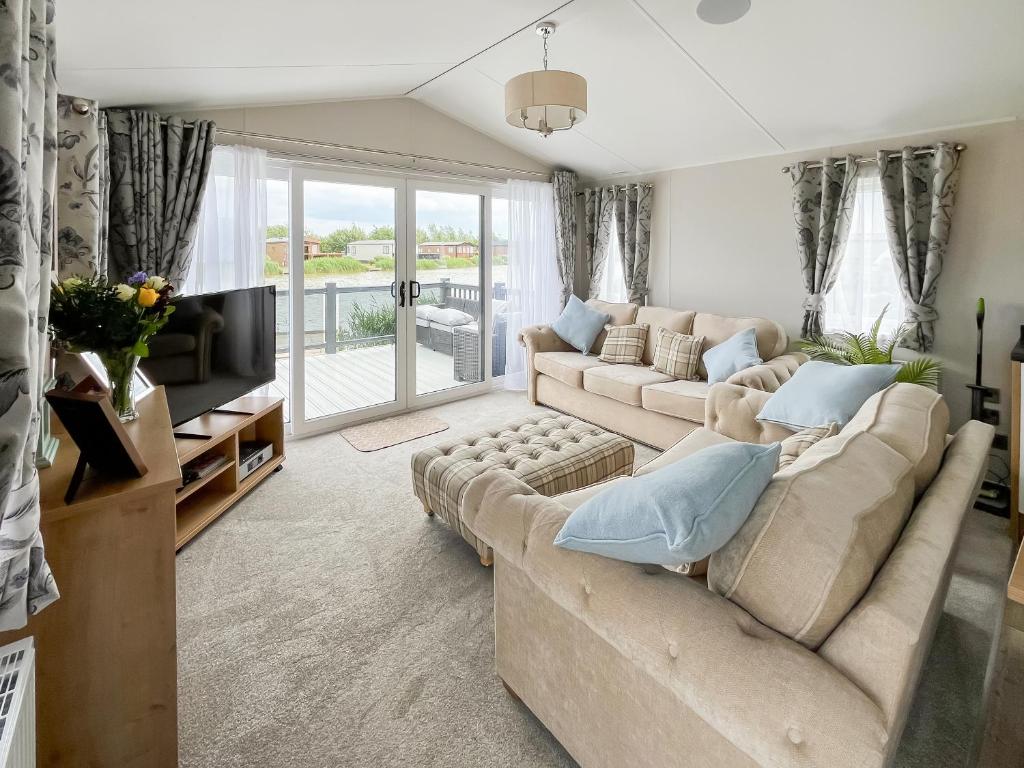 a living room with a couch and a tv at Sandy Shore - Uk37724 in Ingoldmells