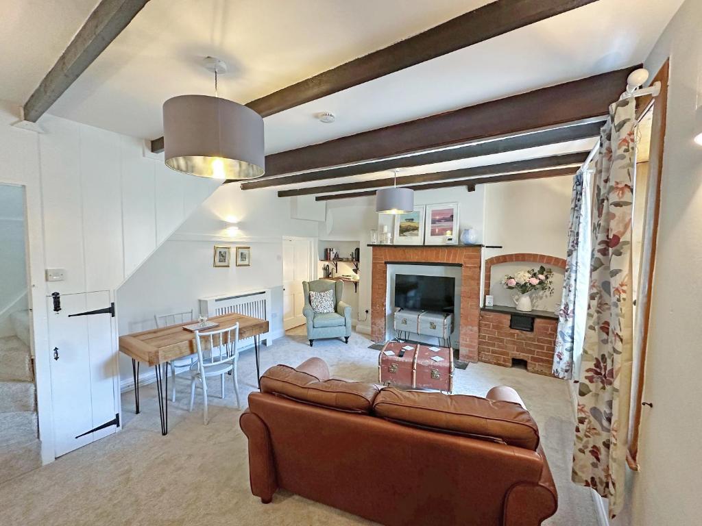 a living room with a couch and a table at Rectory Cottage in Isham
