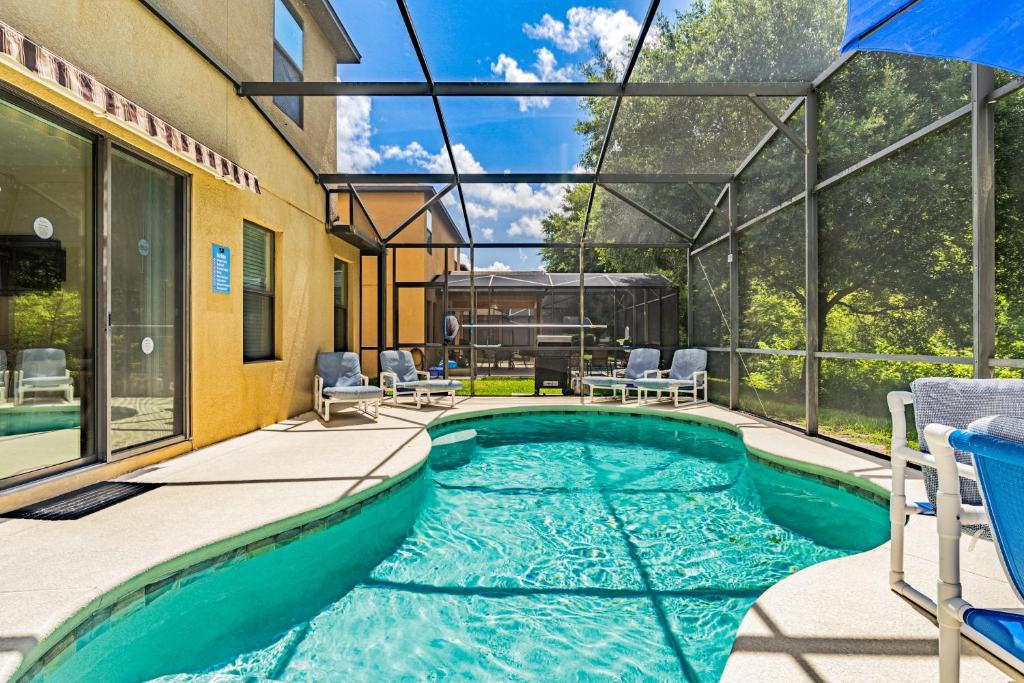 an indoor swimming pool in a house with a glass ceiling at Family Friendly - South Facing Pool - Game Room - Gated - Near Disney in Davenport