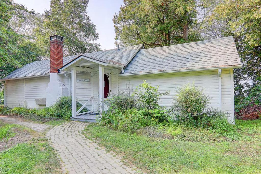 an old white house with a brick chimney and a driveway at 136 Birdie Simcoe Cottage private Beach, Kayak in Georgina