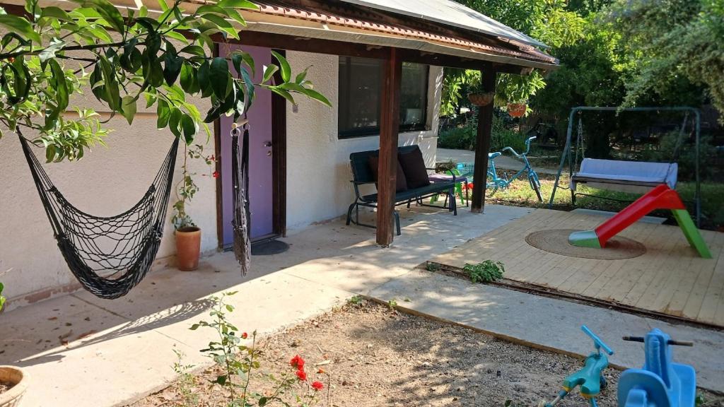 a backyard with a hammock and a house at Little Hula in Yesod Hamaala