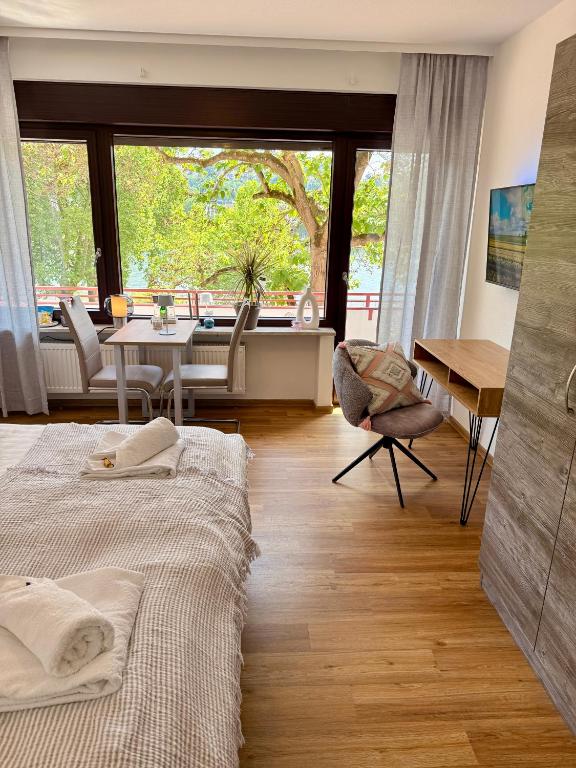 a bedroom with two beds and a table and chairs at Uferglanz - Balcony, view, sparkling wine, snacks in Koblenz