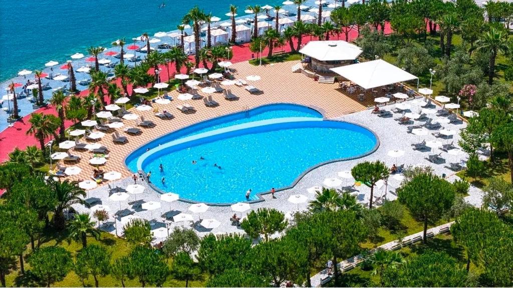 an overhead view of a swimming pool with umbrellas and chairs at Rana E Hedhun Llugani Apartments in Lezhë