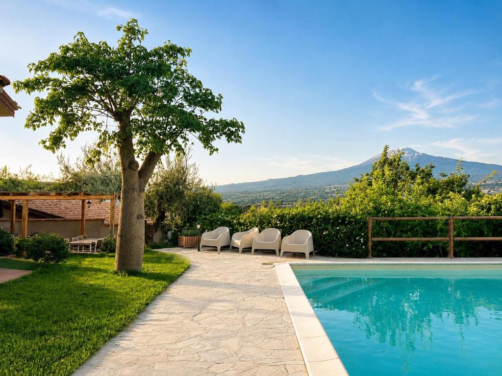 a villa with a swimming pool and a tree at Il Piccolo Aranceto in Motta SantʼAnastasia