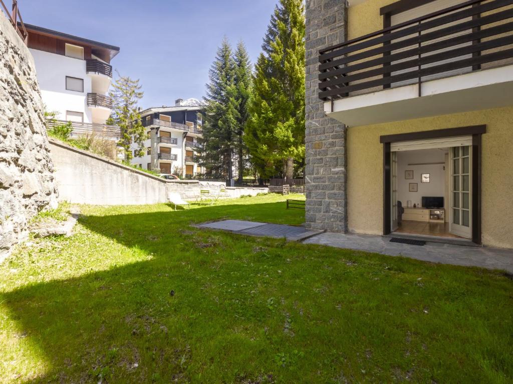 a green yard next to a building at Studio Tigli-2 by Interhome in Madesimo