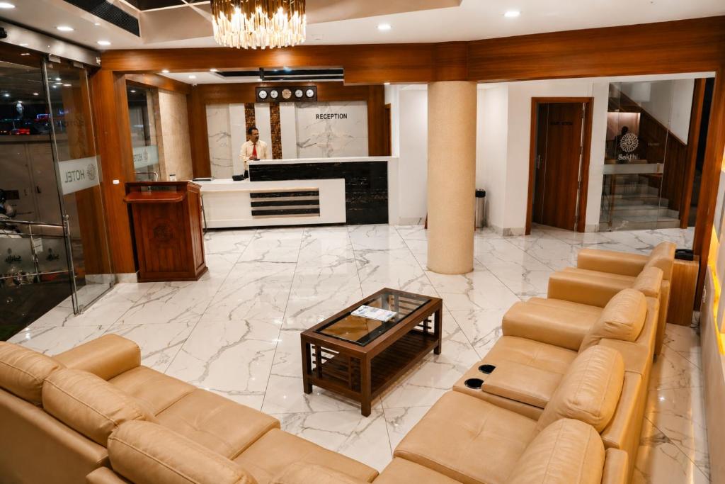 a living room with a couch and a coffee table at Hotel Sakthi in Kottayam