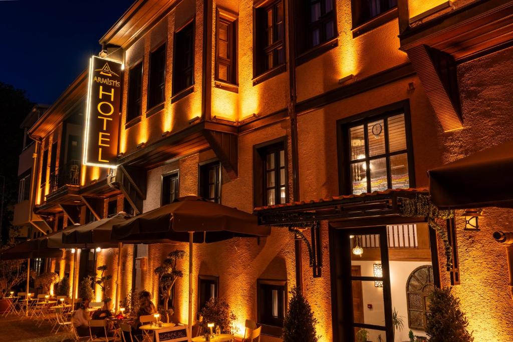 ein Gebäude mit Tischen und Sonnenschirmen davor in der Unterkunft Armistis Hotel in Mudanya