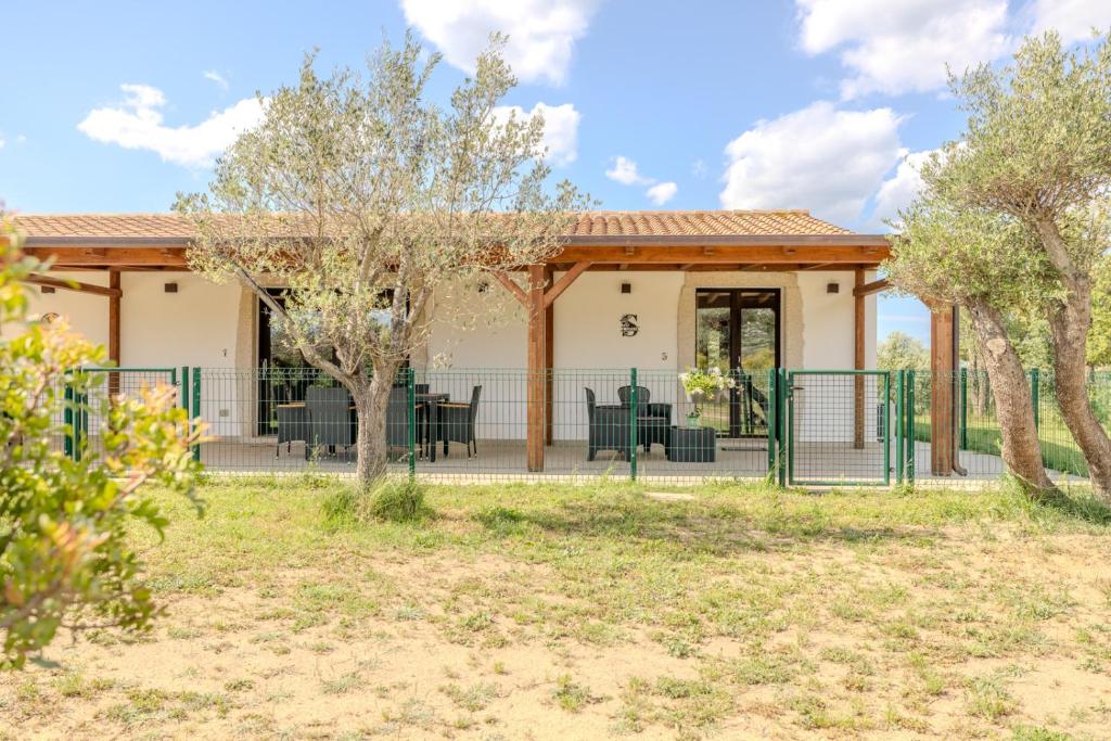 a house with a fence and trees at S'istella suite in Olbia