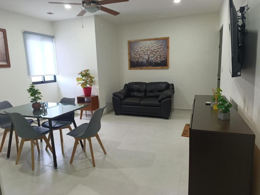 a living room with a black couch and a table at Departamento comodo en Ubicacion Privilegiada in Mérida