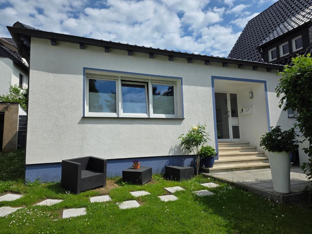 a white house with a window and some grass at Ferienhaus Schwerte Ergste im Ruhrtal in Schwerte