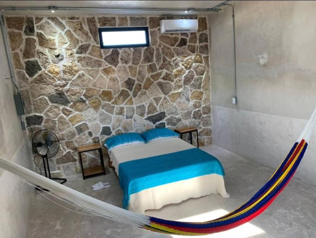 a bed in a room with a rock wall at Departamento comodo en Progreso 1 Recamara 3 personas in Progreso