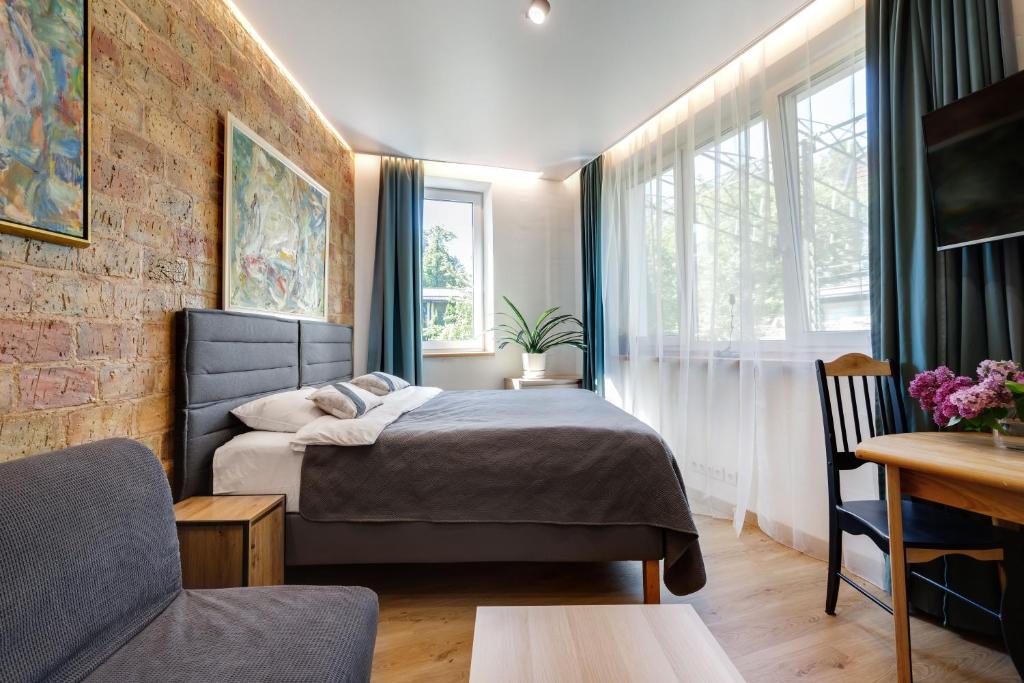 a bedroom with a bed in a room with a table at House of Sun in Vilnius