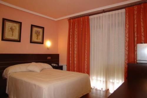 a bedroom with a bed and a large window at Hotel Santa Teresa in Ávila