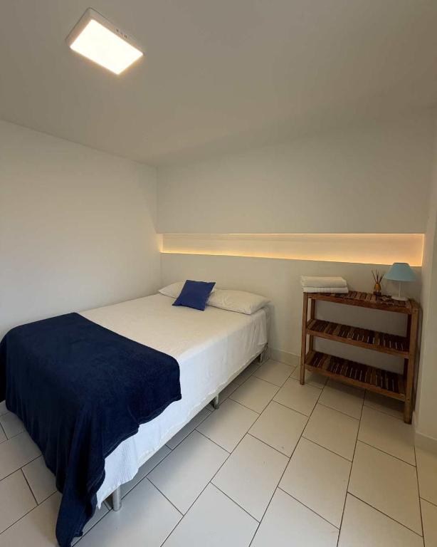 a bedroom with a bed with a blue blanket at Casa da Lua Buzios in Búzios