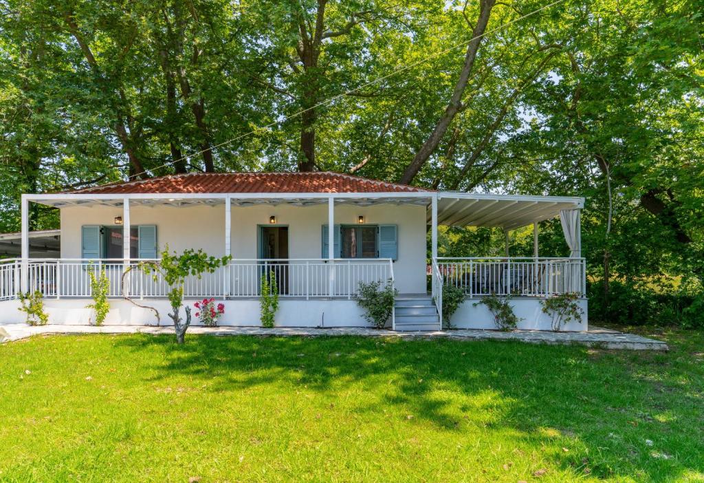 a white house with a porch and a yard at Pappous workplace in Skiathos