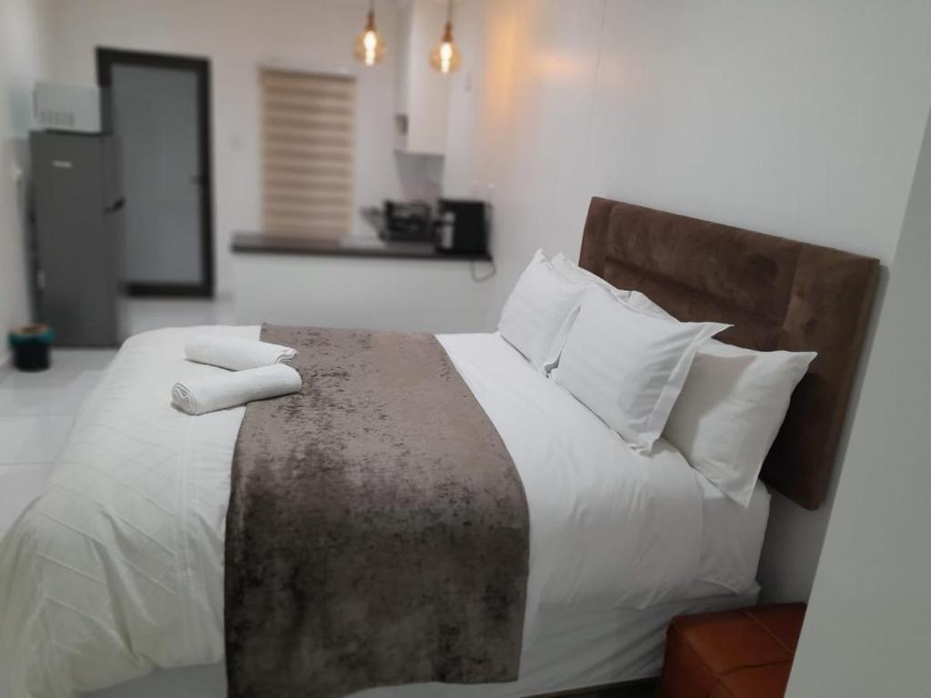 a bedroom with a bed with two white pillows at Ultimate Grace in Pretoria