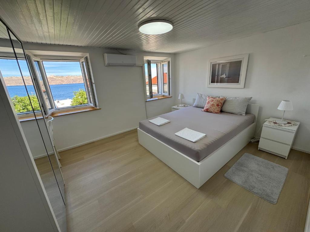 a bedroom with a bed and a glass shower at Apartment BELLA in Karlobag