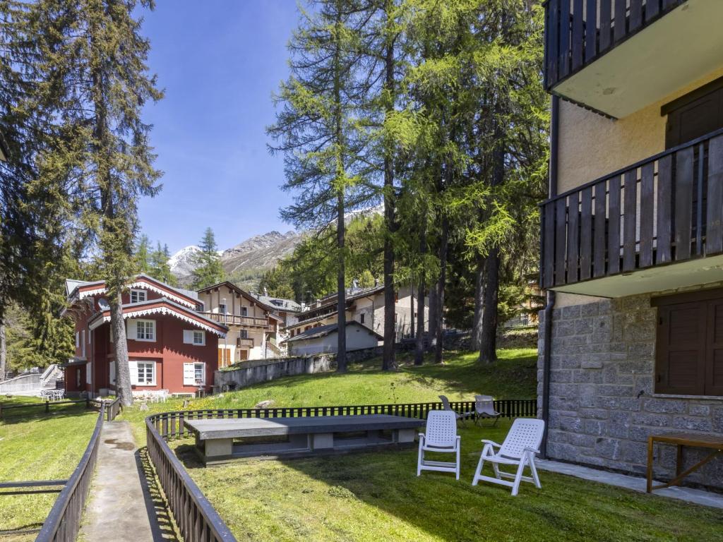 a group of chairs sitting on the grass next to a building at Apartment Villa Adele by Interhome in Madesimo