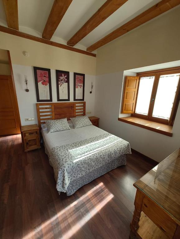 ein Schlafzimmer mit einem Bett und zwei Fenstern in der Unterkunft HOTEL EL RASTRO - Palacio Duque de Tamames - in Avila