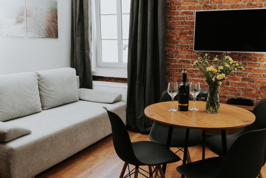 a living room with a couch and a table with wine glasses at Złota Brama - Old Town Apartment 1 in Gdańsk